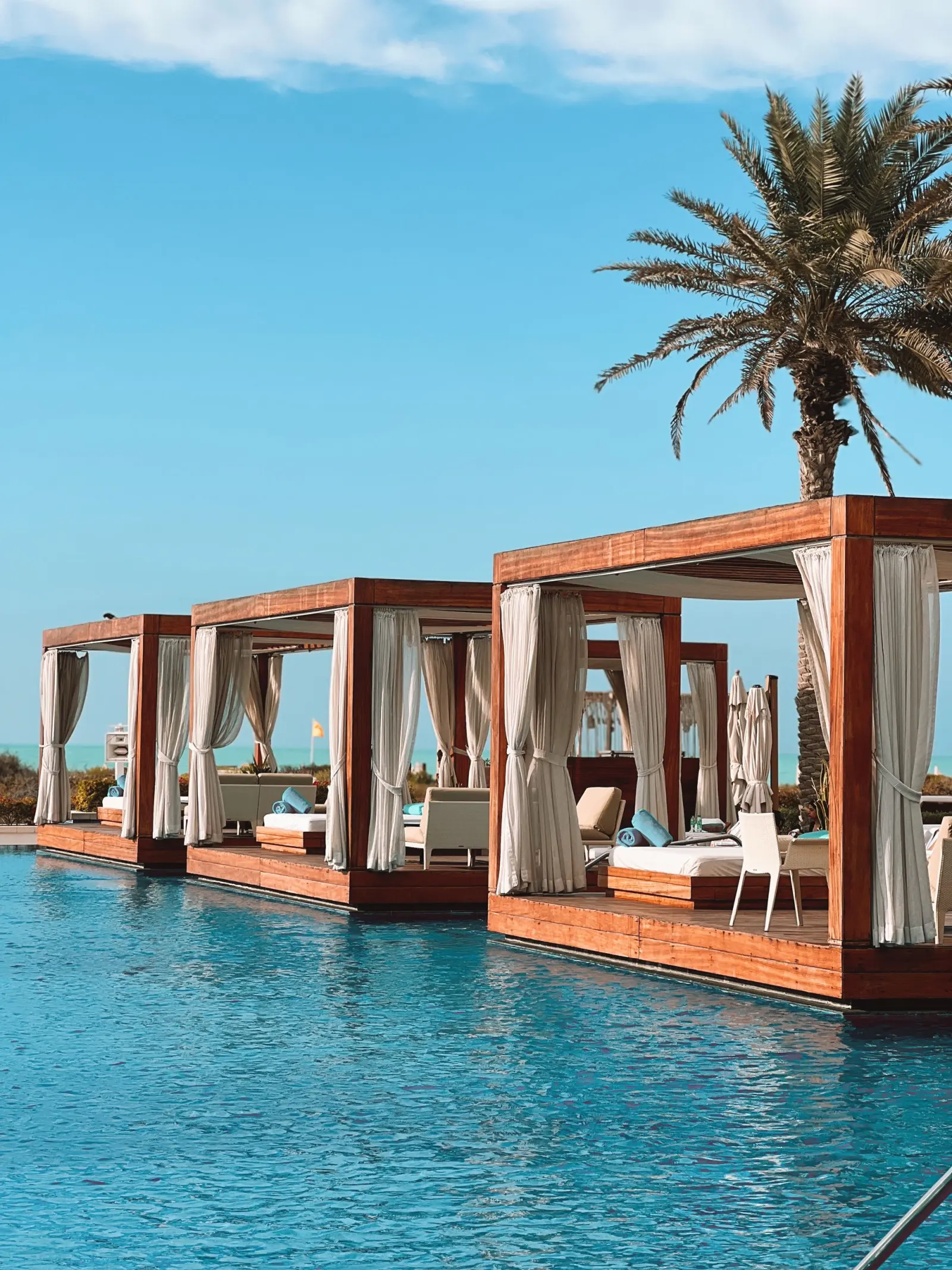 Beach cabanas and loungers on white sand