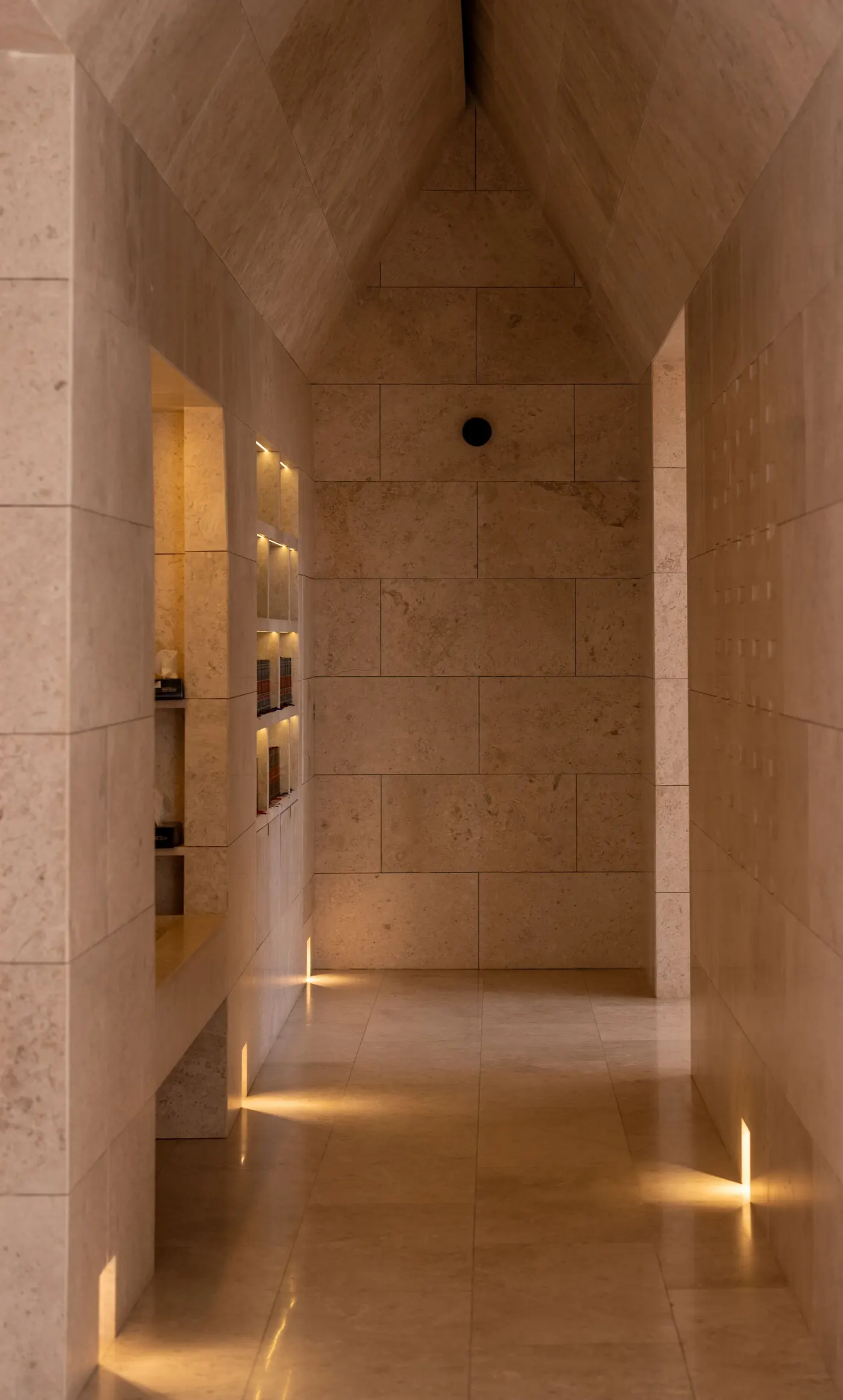 Stone-lined hallway leading into a bright interior